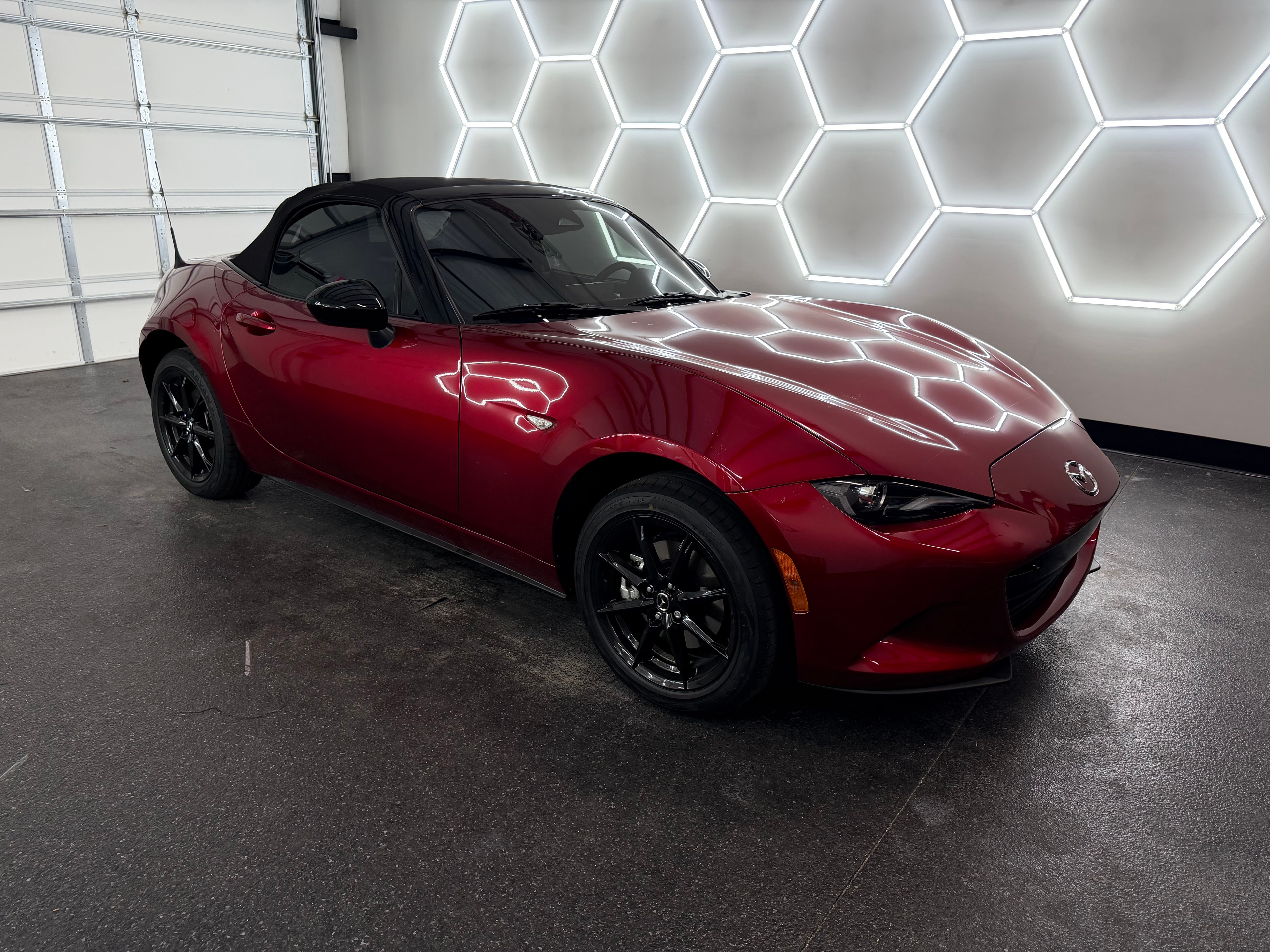 Red Mazda MX-5 with window tint in shop